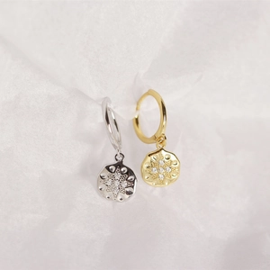 Detailed macro view of S925 silver eight-pointed star hoop earrings in gold and silver