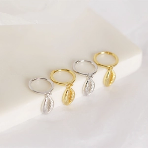 Detailed macro view of S925 sterling silver shell earrings in gold and silver finishes