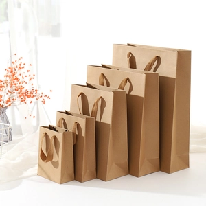 Five assorted brown kraft paper gift bags in various sizes arranged on a white surface