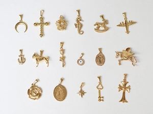 Detail view of 18K gold plated charms featuring rose, seahorse, and celestial shapes