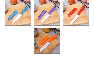 Macro view of colorful stainless steel fruit knives with protective sheaths on wooden board