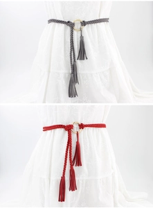 Detail of hand-woven waist belts in grey and red with elegant gold metal ring buckles