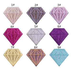 Macro detail of nine colorful diamond-shaped sequin embroidery patches in a grid layout