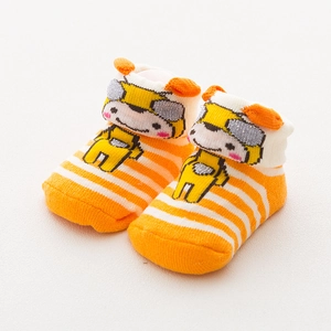 Close-up of baby socks featuring orange stripes and 3D yellow cartoon animal decorations