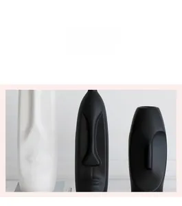 Detailed view of matte black and white ceramic face vases with Nordic minimalist design