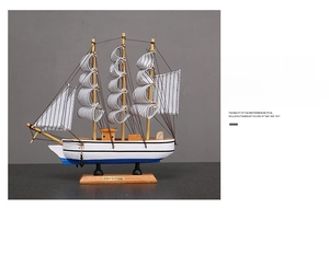 Détail d'un voilier miniature en bois de style méditerranéen avec des voiles à rayures