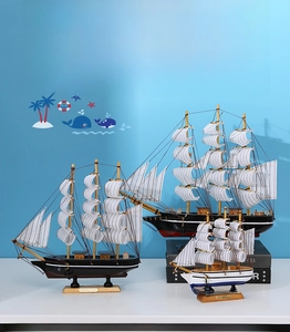 Ensemble de trois maquettes de voiliers en bois avec voiles à rayures et gréement détaillé