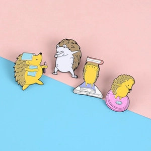Detail view of four creative cartoon hedgehog enamel pins in various poses and colors
