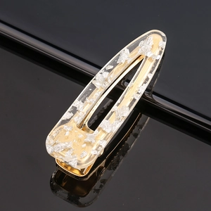 Macro detail of rectangle acetate hair clip with silver foil flakes on black mirror