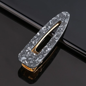 Close-up of gray stone pattern acetate snap hair clip with a polished gold metal base