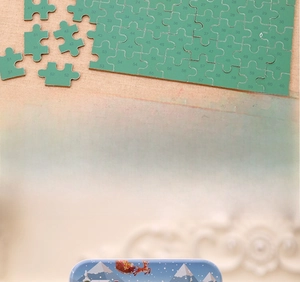 Detail of wooden Christmas jigsaw puzzle with numbered back and metal storage box