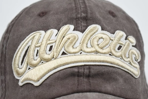 Macro shot of 3D gold athletic embroidery on washed cotton baseball cap texture
