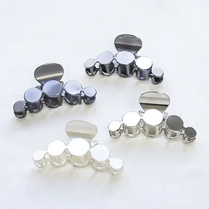 Minimalist geometric alloy hair claws in four metallic colors with overlapping circular design