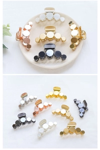 Detail of round geometric metal hair claws in gold, silver, and rose gold finishes