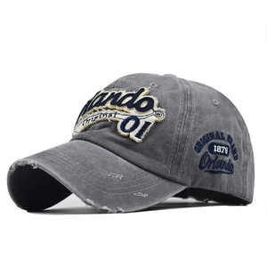 Detail of grey washed denim baseball cap with Orlando embroidery and distressed edge finish