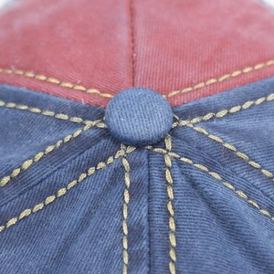 Detailed macro shot of the navy top button and twill fabric texture on a baseball cap