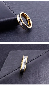Gros plan sur une bague bicolore en acier inoxydable avec bord doré et diamant incrusté