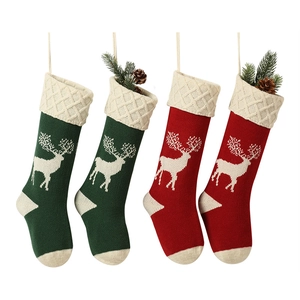 Set of four red and green knitted Christmas stockings with white reindeer patterns