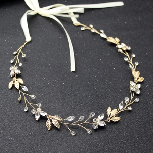 Detail of bridal hair band with golden leaves and crystal beads on black background