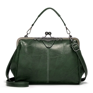 Vintage green leather handbag with metal frame clasp and detachable shoulder strap