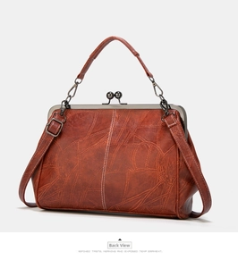 Detailed back view of a vintage caramel brown leather handbag with antique metal clasp