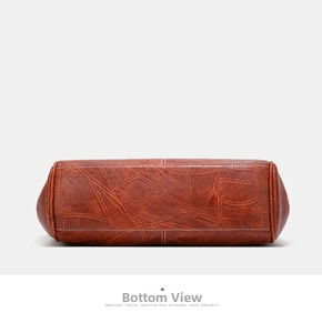 Detailed bottom view of brown leather bag featuring contrast stitching and fine texture