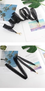 Detail of black crochet lace belt with gold tips and faceted crystal pendants