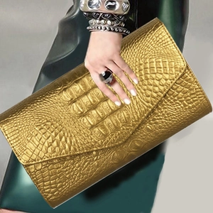 Elegant gold crocodile pattern envelope clutch bag held by a model for parties