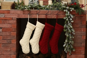 Detail of red and cream knitted Christmas stockings on a brick fireplace mantel