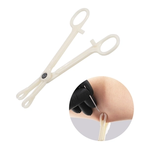 White disposable plastic body piercing clamps shown with professional hand usage detail