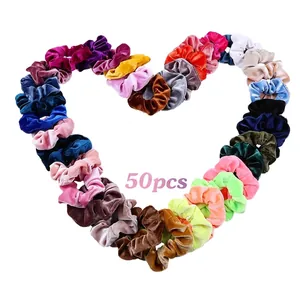 Lot de 50 chouchous en velours colorés disposés en forme de cœur sur un fond blanc