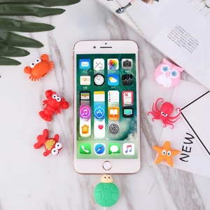 Flat lay of colorful cartoon animal silicone cable protectors around a smartphone