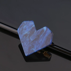 Macro shot of blue marble heart hair clip with glitter detail and metal fastener