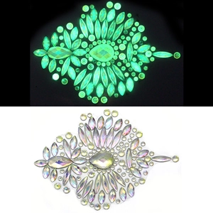 Glow-in-the-dark face gems showing green luminescence and iridescent finish in daylight