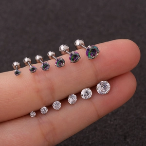 Macro shot of zircon stud earrings in various sizes and colors displayed on fingers