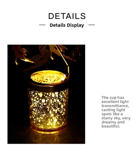 Detail of star-projecting glass candle holder with warm glow and fairy metal ornament