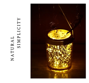 Detail of mercury glass jar with warm LED fairy lights and metal fairy silhouette decor