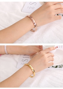 Close-up of screw motif gold and rose gold bangles with inlaid crystals on the wrist