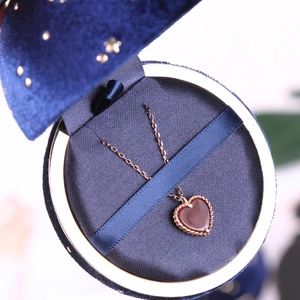 Rose gold heart pendant necklace with red agate in a blue starry velvet jewelry box