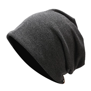Detail of dark grey knit slouchy beanie showing dense texture and soft ribbed fabric