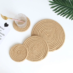 Macro detail of natural jute woven coasters with spiral texture in a set of four pieces