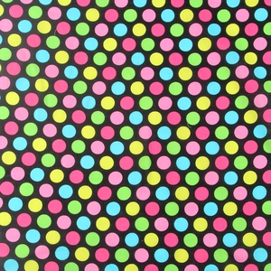 Detailed view of colorful polka dots on black cotton fabric showing texture and pattern