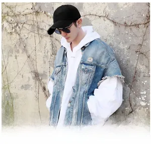 Outdoor street shot of a black baseball cap with white Vetements text on the brim