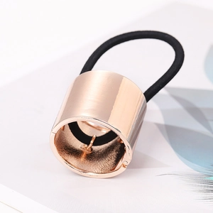Close-up of black elastic hair tie with golden cylindrical metal ponytail buckle