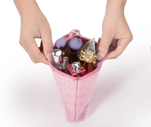 Pink fabric makeup bag with gold dots showing large storage capacity for brushes