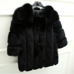 Close-up detail of luxury black faux fur coat with thick collar and striped texture