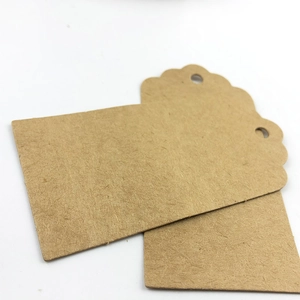 Set of two blank brown kraft paper gift tags with scalloped edges and pre-punched holes