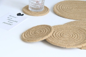 Macro shot of natural braided jute coasters and placemats showing round fiber texture