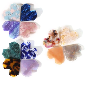 Colorful heart-shaped acetate hair clips with marble texture for women on white background