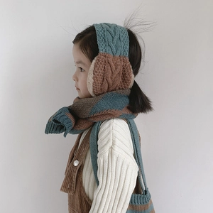 Detail of kids knitted earmuffs and scarf set with chunky cable pattern in teal and brown